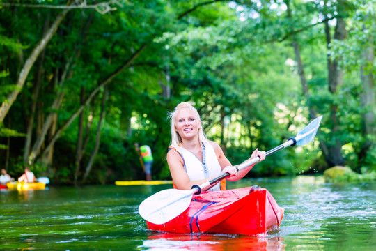 夏天，妇女在森林河上划独木舟