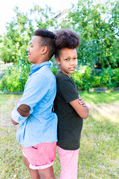 兄弟姐妹，两个黑人孩子，肩并肩站在花园里