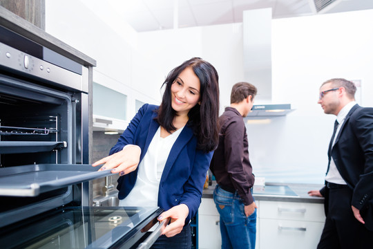 在工作室或家具店为家庭厨房挑选烤箱的妇女