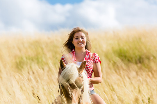 夏日草地上骑马的女人
