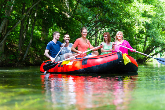朋友们在森林河或小溪的橡皮艇上划水
