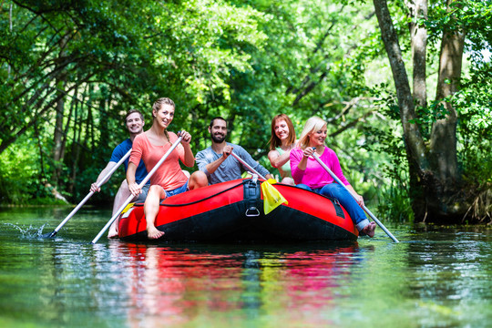 朋友们在森林河或小溪的橡皮艇上划水