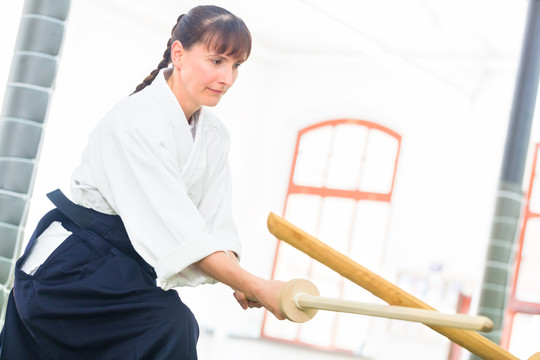 武术学校合气道训练中的女子用木剑搏斗