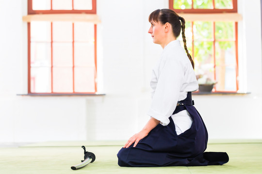 武术学校合气道训练时坐在垫子上的女子