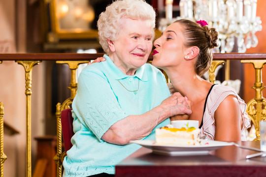 老太太和孙女在老式咖啡馆拿着蛋糕