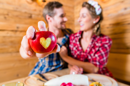 相爱的情侣在阿尔卑斯山上，一颗心被切成了一个苹果
