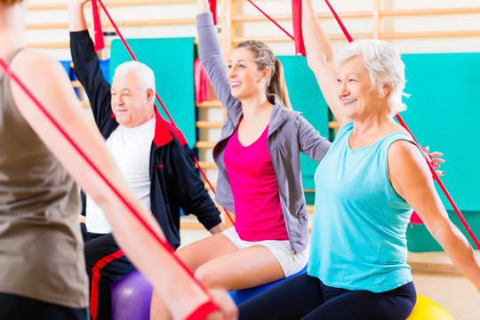 老年人在健身房的健身课程中使用弹力带进行锻炼