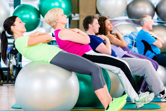 年轻人和老年人在健身房锻炼，白人和白人的多样性