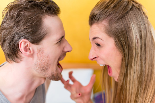 年轻的已婚夫妇，女人和男人，在激烈的斗争中愤怒地盯着对方