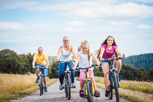 一家人下午在夏日的乡间骑自行车