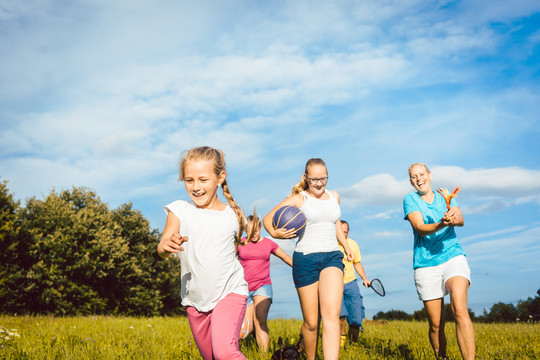 夏季景观中的家庭玩耍、跑步和运动