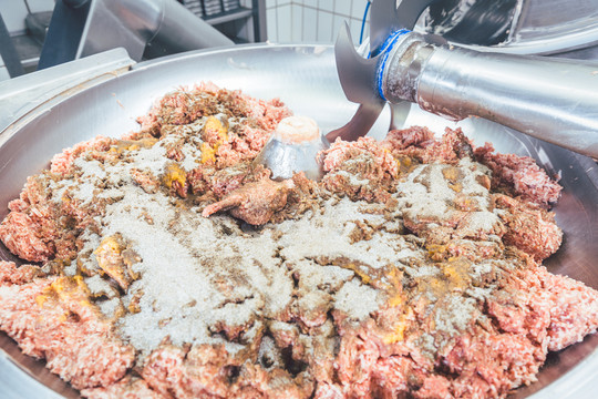 肉糜在屠宰厂的绞肉机中用香料制成