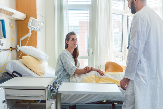 病房查房时，病人在病床上等待医生看她