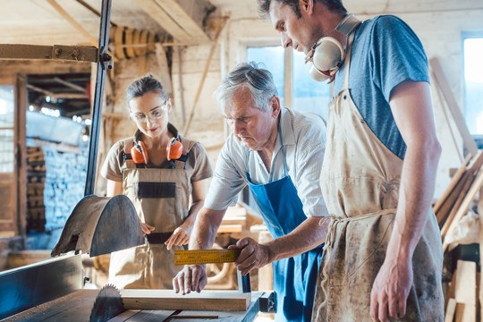 经验丰富的木匠大师将知识传授给年轻的同事
