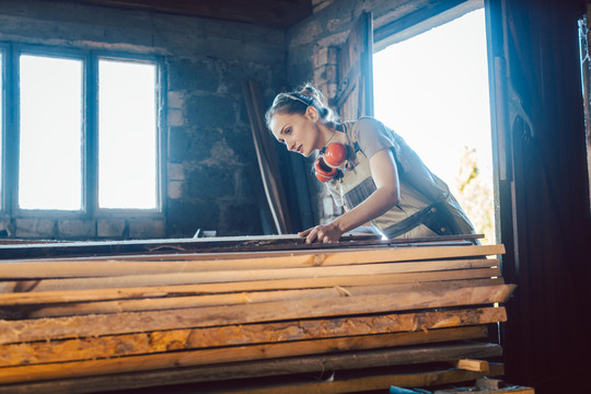 女木匠在仓库里为下一个项目挑选木材