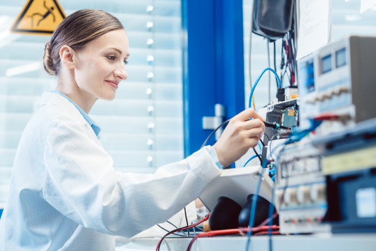 一名女工程师在实验室的测试台上测量电子产品的EMC合规性