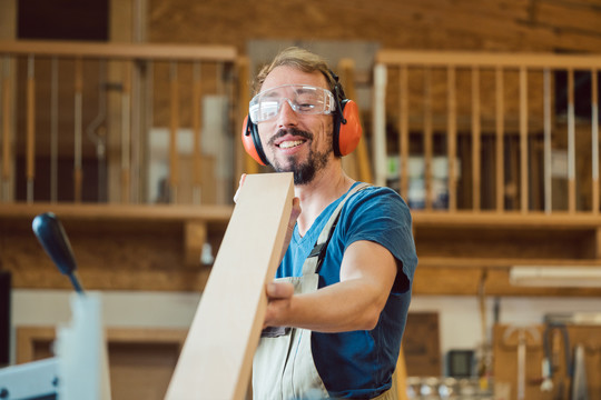 勤劳的木匠检查他的木制品是否有缺陷