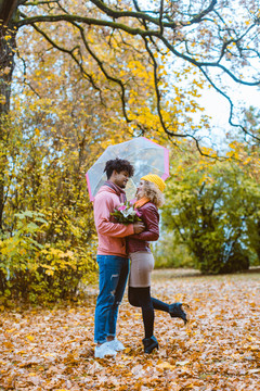 不同种族的男人和女人在秋天散步时拥抱