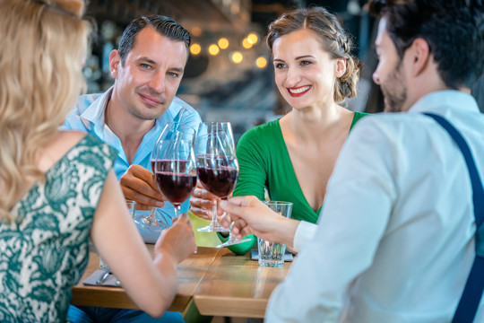 在一家高档餐厅里，男人和女人们用红酒敬酒