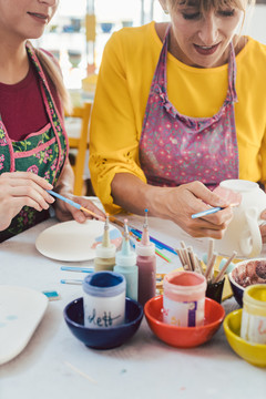 两个女朋友在一个业余工作室里画自己的手工陶瓷