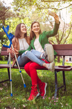 一位脚踝扭伤的女士和她的朋友拍照或自拍