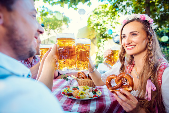 在巴伐利亚的酒吧里，一对夫妇拿着大量啤酒互相碰杯