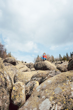 站在岩石上在野外徒步旅行的女人