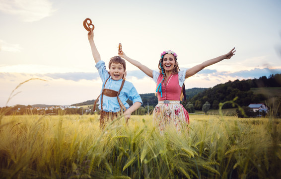 快乐的母子俩在巴伐利亚州的草地上跳来跳去，玩得很开心
