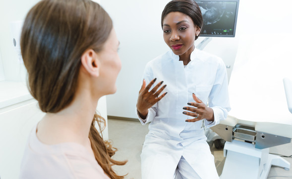 黑人妇科医生给妇女看怀孕早期的超声波检查
