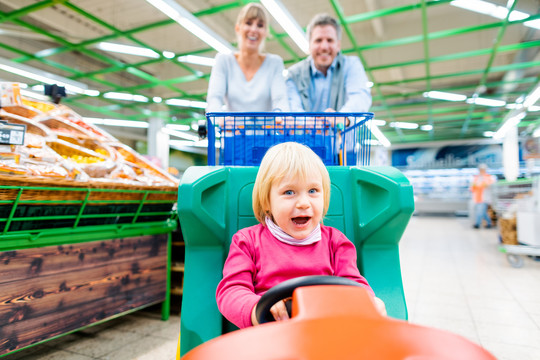 情侣们在超市购物时使用一种特殊的儿童手推车以获得更多乐趣
