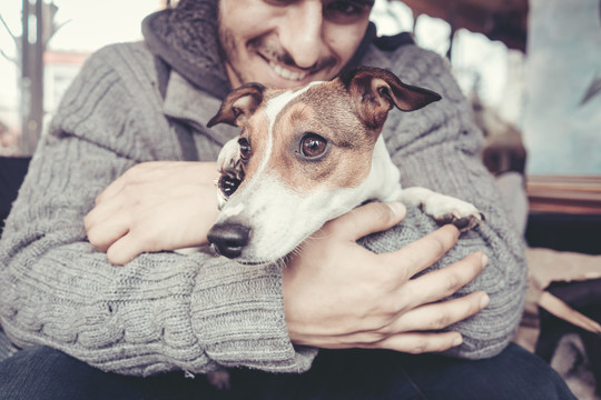 冬天，男人抱着他的猎犬