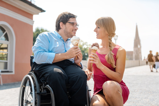一位残疾人和他的朋友在城市远足时在城里吃冰淇淋