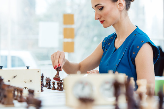 在比赛中下棋的女子移动棋子