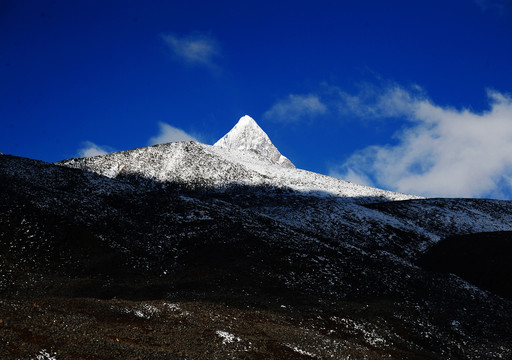 西藏蓝天下一座三角形雪山山峰