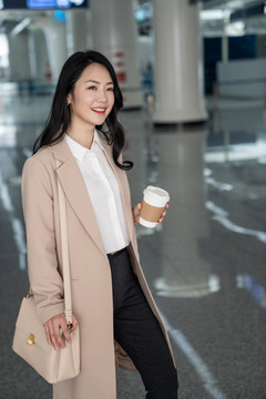 商务女士在机场拿一杯咖啡