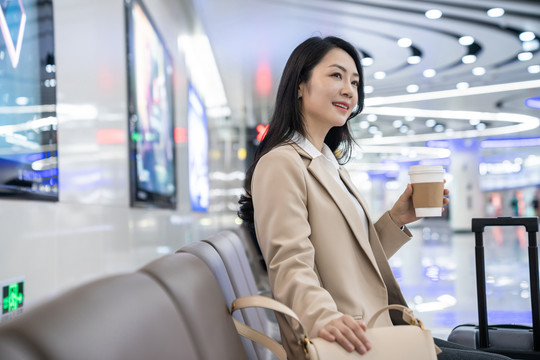 商务女士在机场拿一杯咖啡