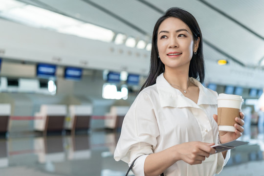 商务女士在机场拿一杯咖啡