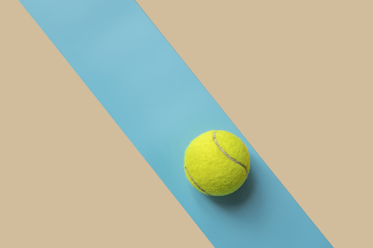 拼接背景中放着一只网球