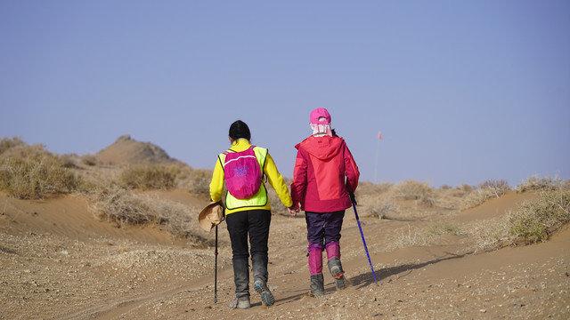 沙漠徒步之两个人携手的背影