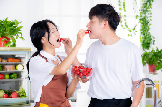 情侣在厨房甜蜜护喂西红柿