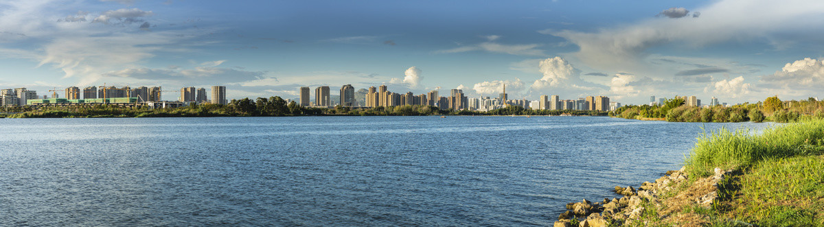 蓝天白云滇池湖畔城市楼群全景图