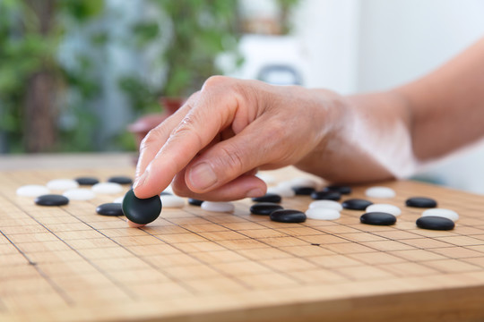 一枚黑色圍棋棋子預要落下