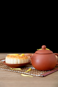桌子上一壶茶和一块月饼