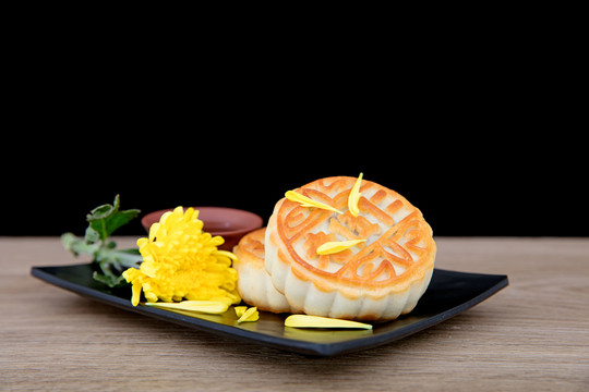 盘子里的月饼和一朵金黄色的菊花