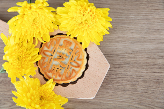 月饼模具和一块月饼及秋天的菊花