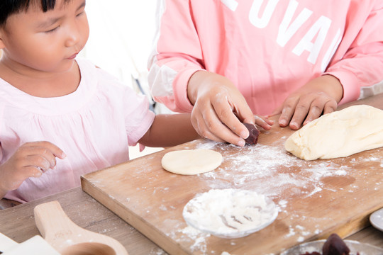 孩子在跟妈妈学习制作月饼