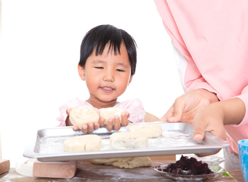 小女孩把做好的月饼放在烤盘里