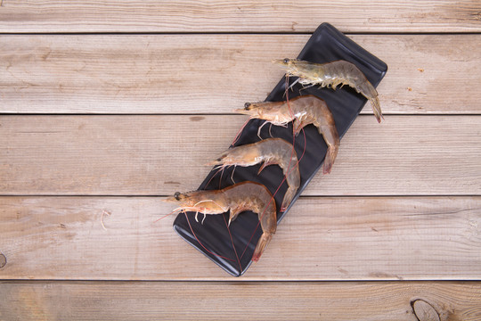 长盘子里放着新鲜的河虾食材