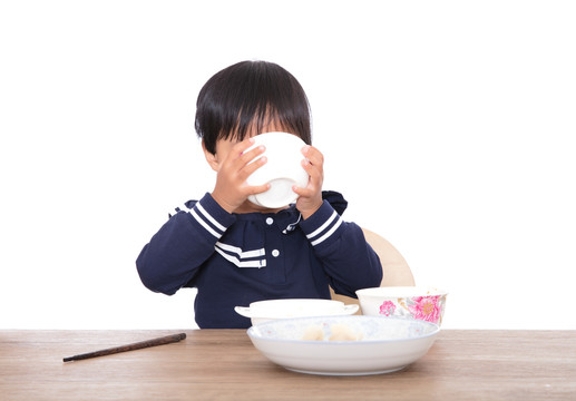 饥饿的黄皮肤小女孩在大口喝汤