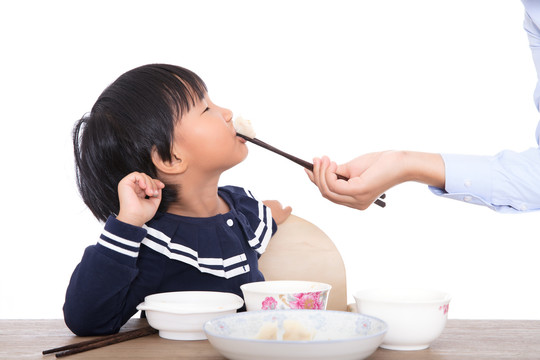 妈妈在喂孩子吃饺子